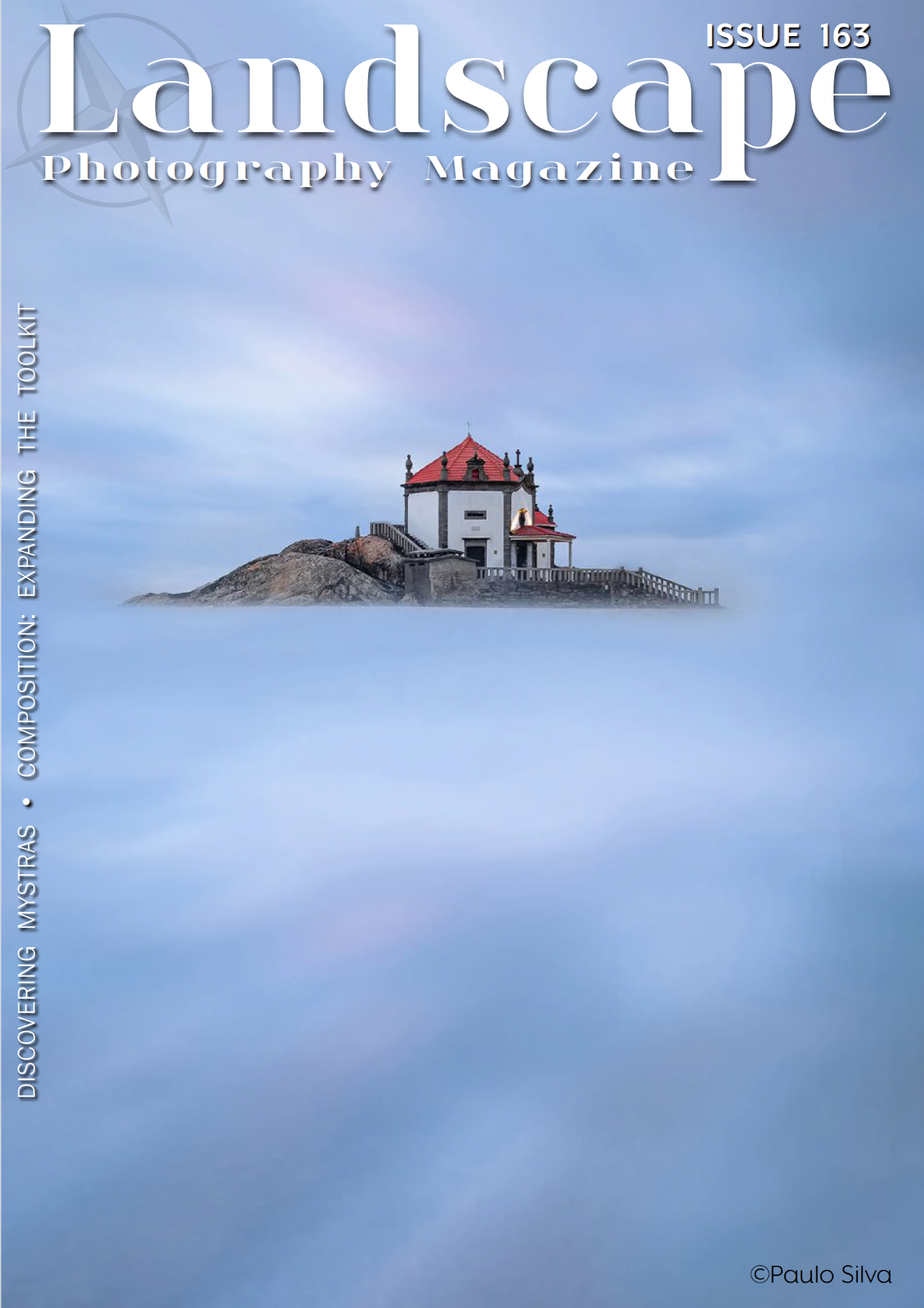 Phare blanc à toit rouge sur un îlot rocheux, ciel bleu, couverture de magazine “Landscape Photography Magazine”.